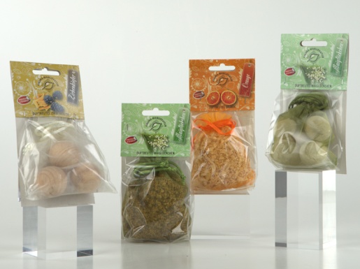 Duftkugel und Duftbeutel in Verpackung nebeneinander aufgereiht auf hellem Hintergrund