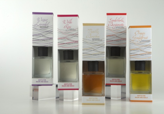 5 Sorten Aromadiffuser in 4eck Glasflasche in wei&szlig;er Verpackung mit bunter Grafik und Schrift auf hellem Hintergrund