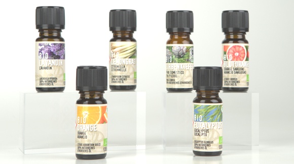 Eine Auswahl an Bio &Ouml;len in 10ml Braunglasflasche mit kindersicherem schwarzen Verschluss und buntem Sortenetikett auf hellem Hintergrund