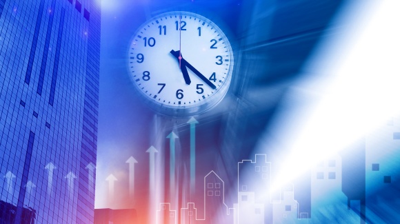 Eine Wanduhr vor einer blau leuchtenden Stadtkulisse mit nach oben gerichteten Pfeilen